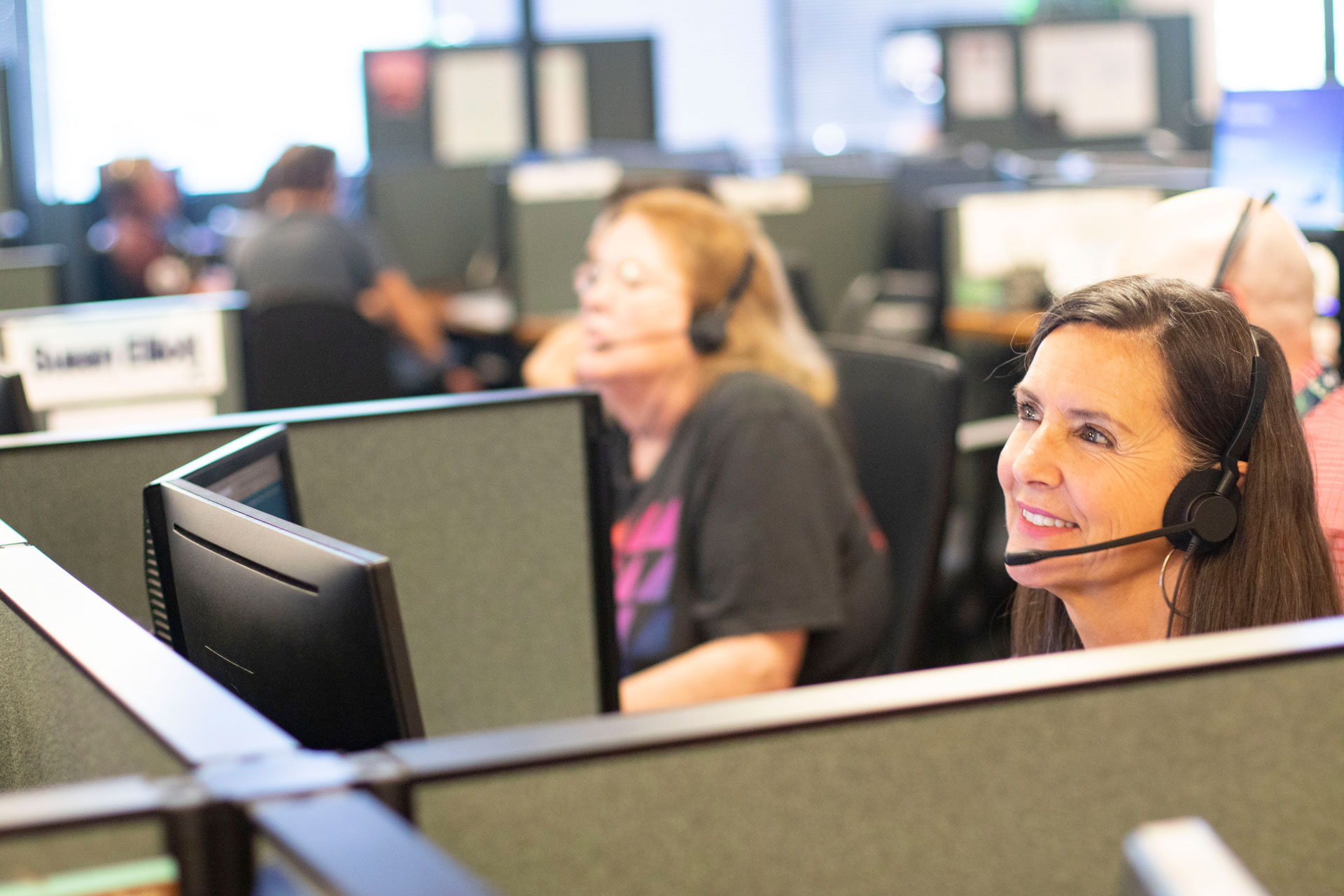 A female customer care agent helping a man and woman check in 