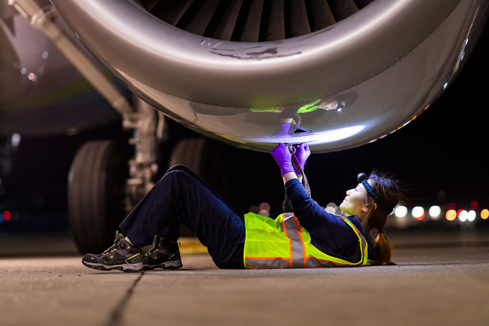 Woman with a wrench in front of a jet turbine