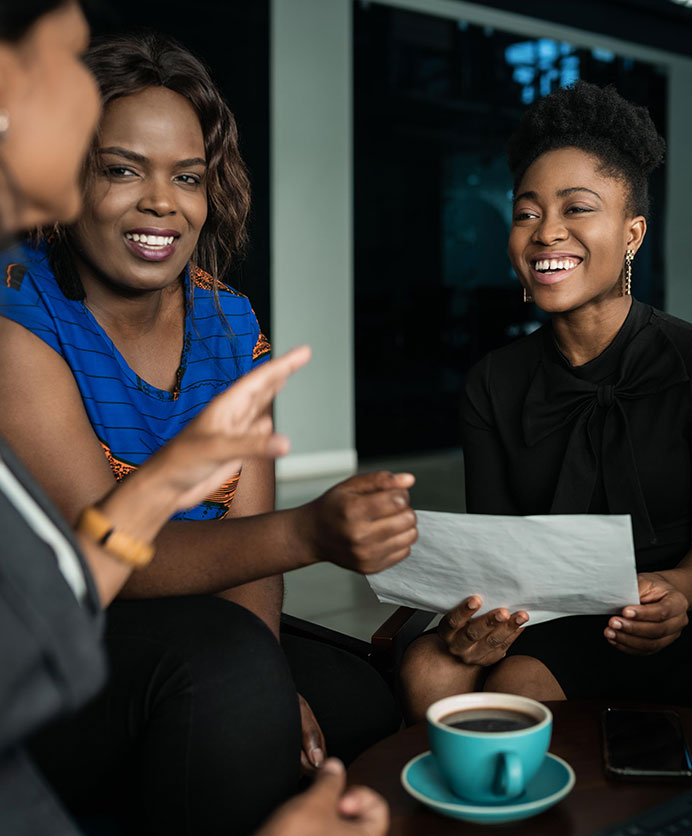 Young African businesspeople going over paperwork during a casual meeting in an office